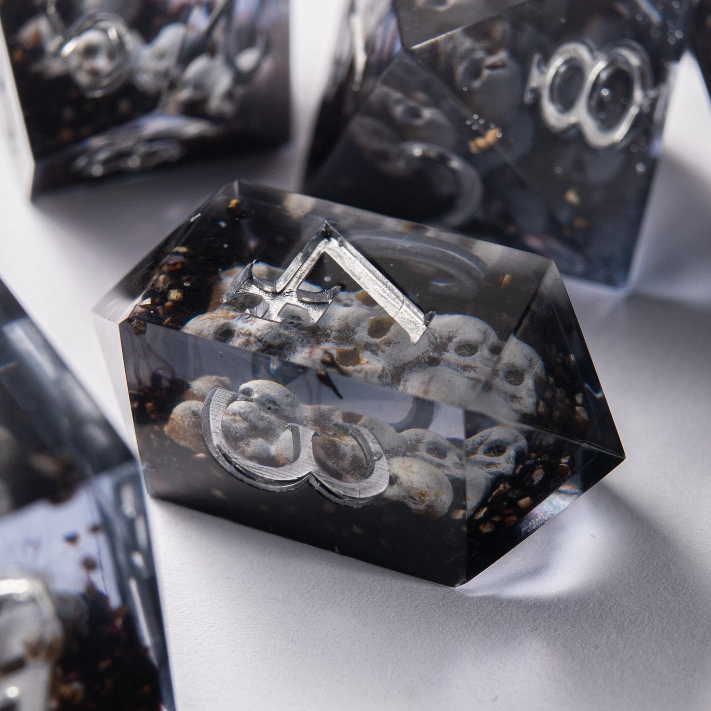 Close-up of Prison of Souls resin D20 – artisan handmade dice with skull inside.