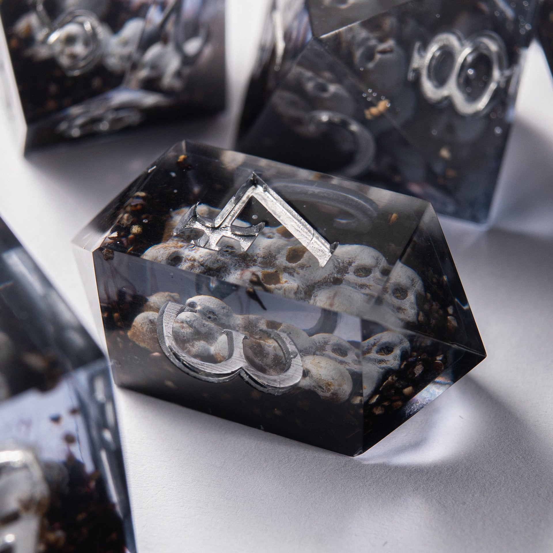 Close-up of Prison of Souls resin D20 – artisan handmade dice with skull inside.