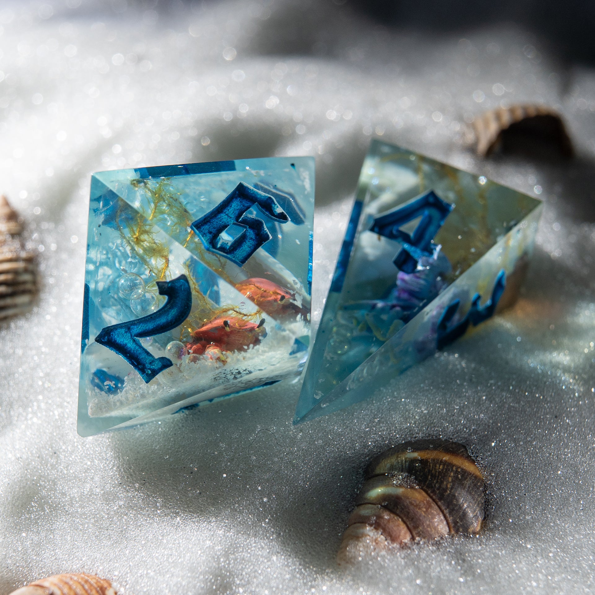 Close-up of custom sea dice – translucent resin D20 with crab miniature and coral for fantasy RPGs.
